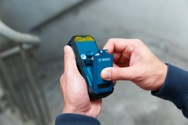 Removing the rechargeable battery pack from a Bosch 50m green beam laser measure.