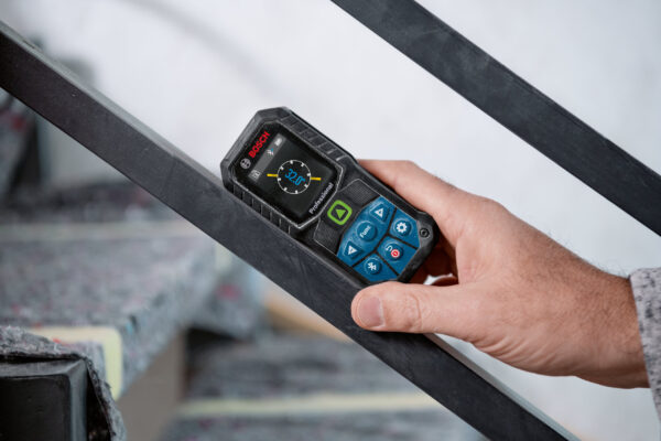 Using the 360-degree tilt sensor on a Bosch 50m laser measure to check stair railing incline.