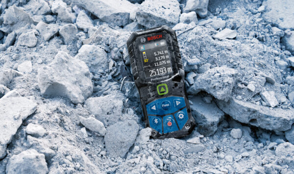 Ruggedized rubber housing on a Bosch 50m laser measure sitting in construction site debris.